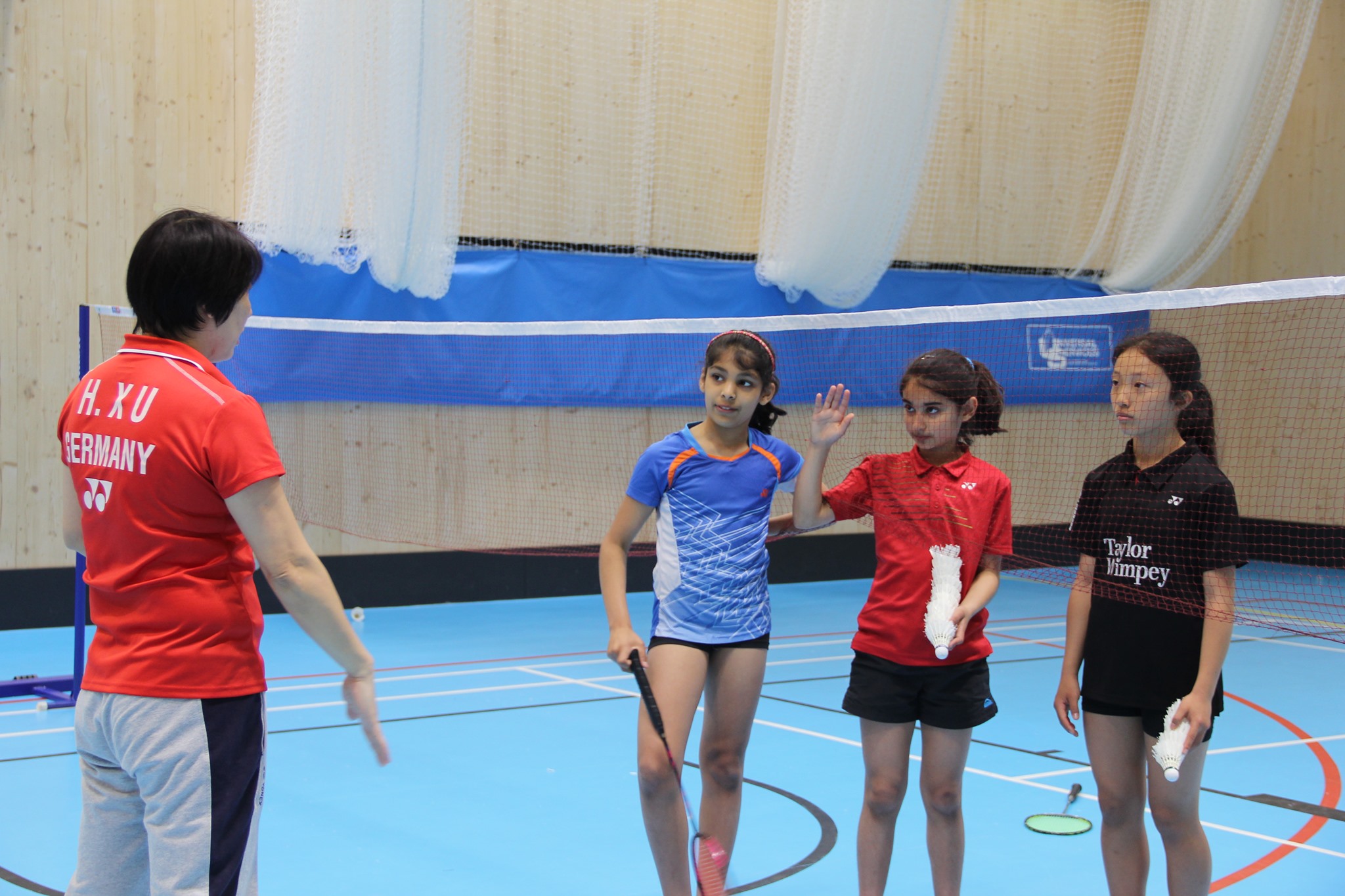 Huaiwen Xu coaching children on the badminton court